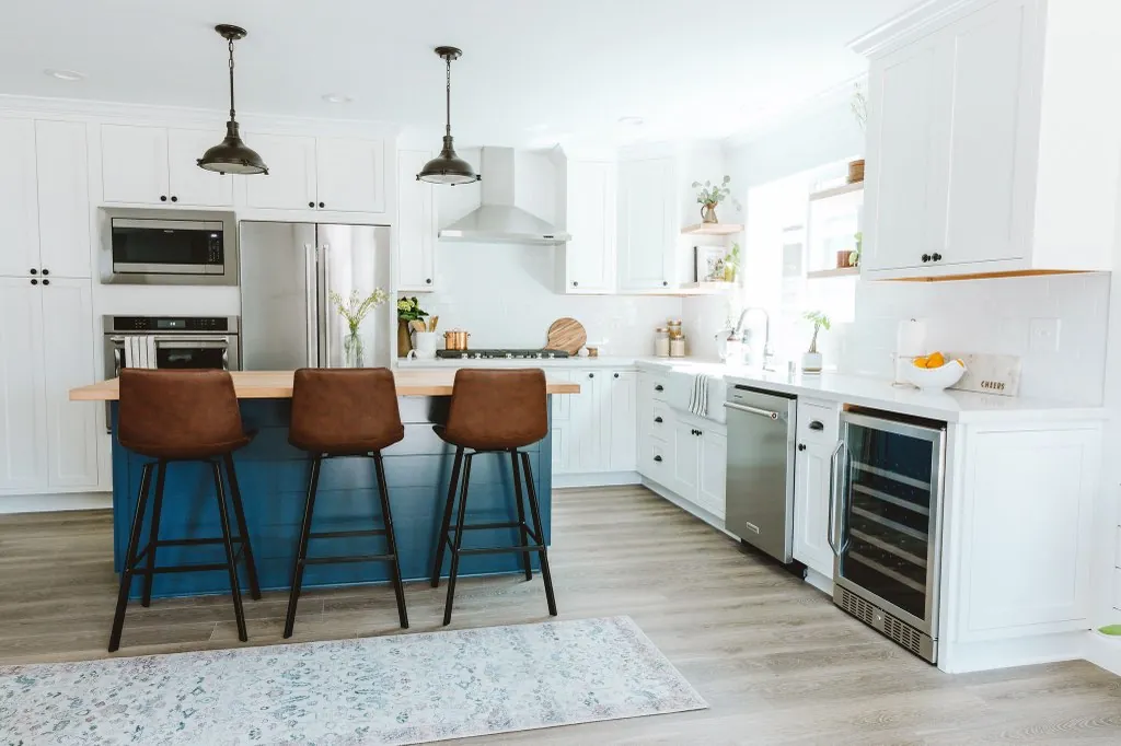 Snow White inset shaker kitchen with navy island, leather stools, and pendant lights